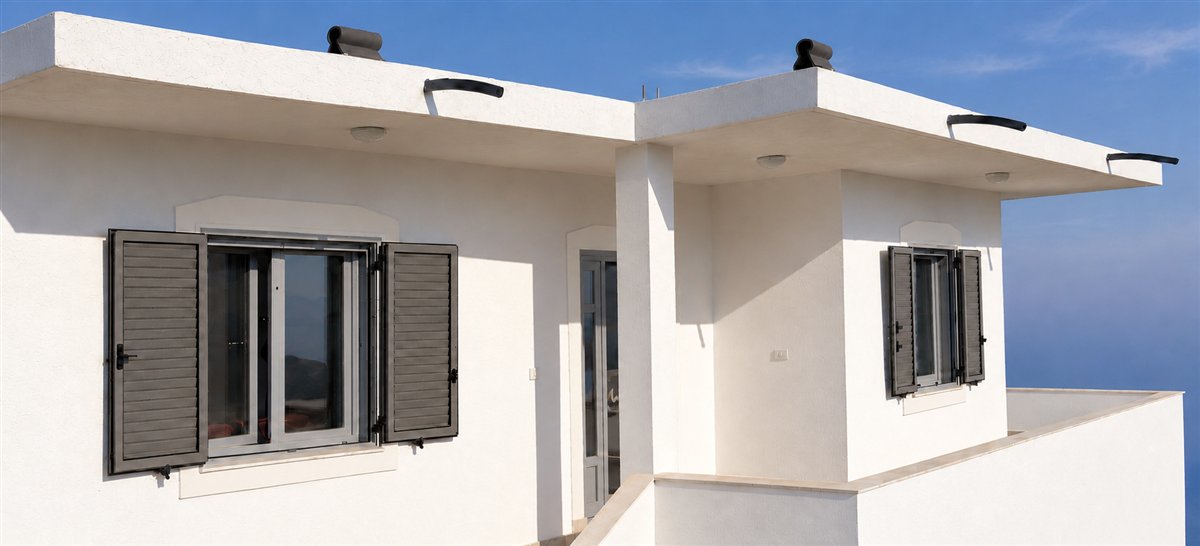 White stucco exterior with charcoal shutters, pale window trim and a white terrace wall